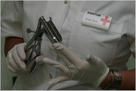 Oberkörper von Doktor Linda Dorn im weißen Kittel und weißen Handschuhen hält ein Metall Gerät für anale Untersuchung in der Hand haltend